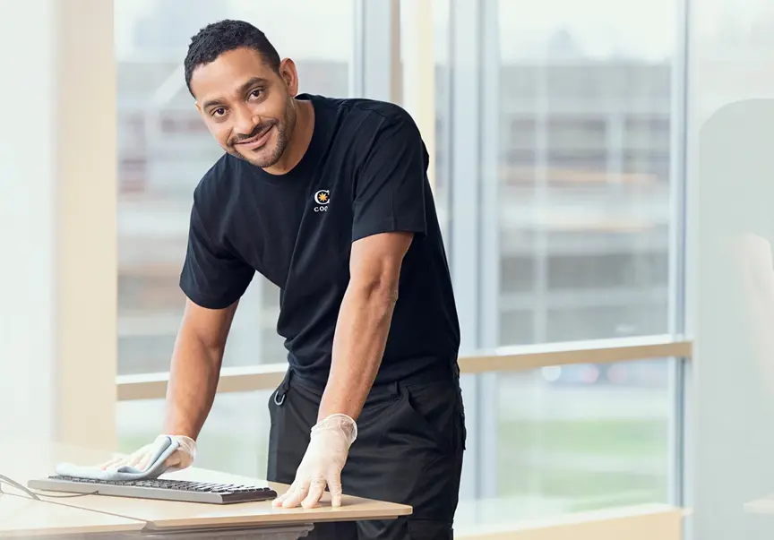 Cleaner wiping keyboard in an office